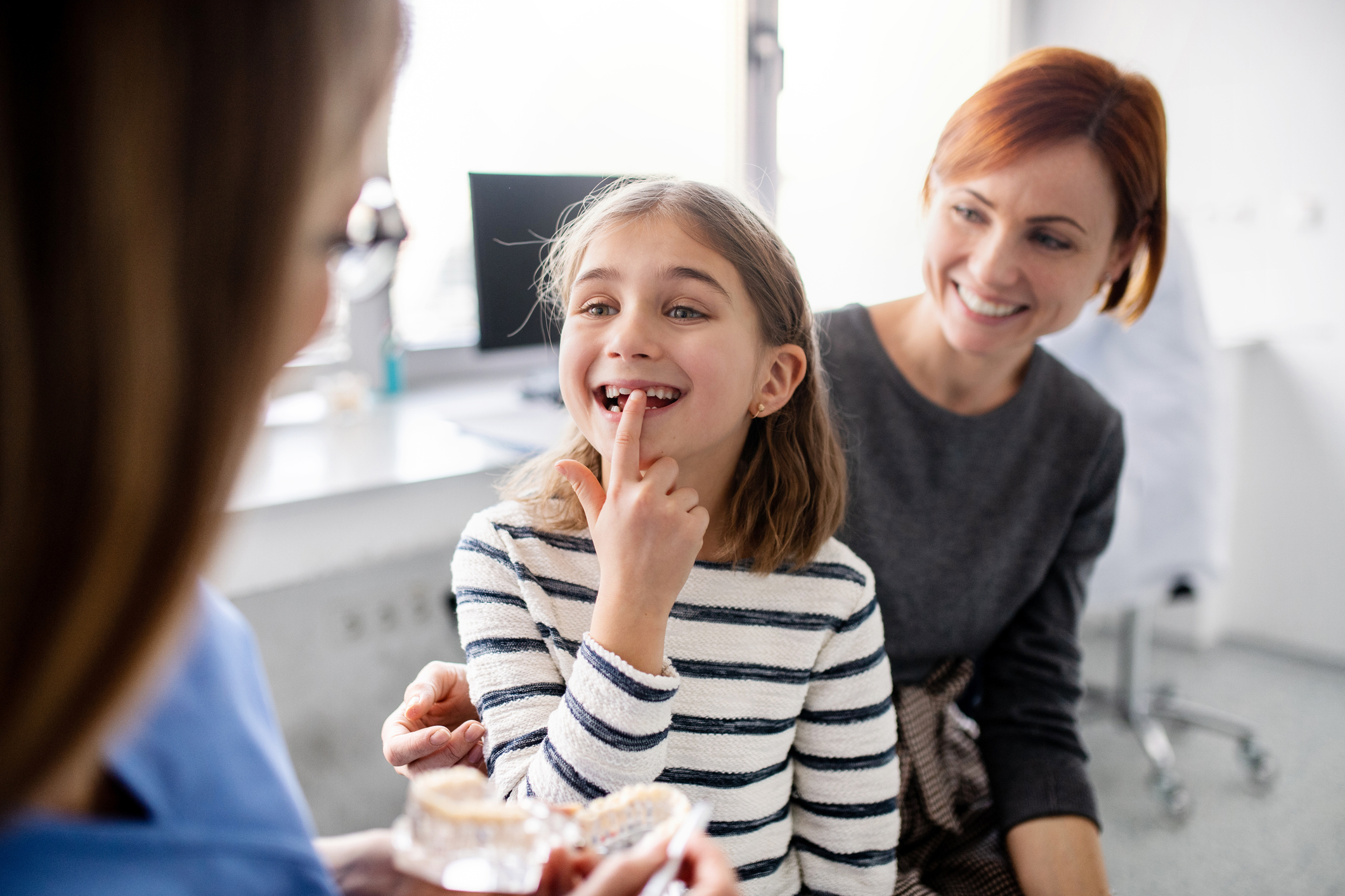 Mother and daughter smiling during orthodontic consultation